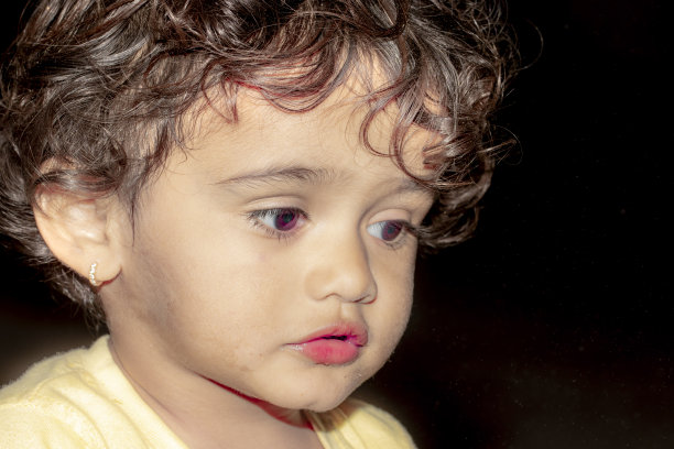 近脸照片的可爱小印度可爱的印度男孩婴儿与黑色和低调的创意背景图片下载