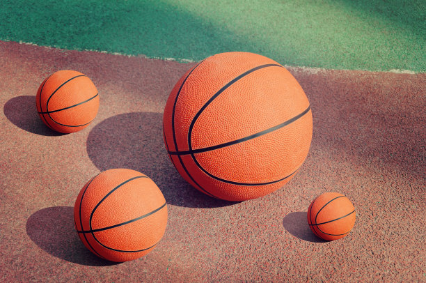 橙色的篮球球躺在橡胶球场的侧面。图片下载