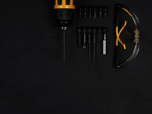 无绳电钻-带电钻的螺丝刀。构造工具集。黑色背景。产品维修。专业维修设备。图片下载