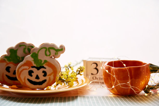 快乐的万圣节静物南瓜杯和自制的可爱的南瓜形状的饼干和万圣节的日期。大气美学的秋季假日概念。乡村生活图片下载