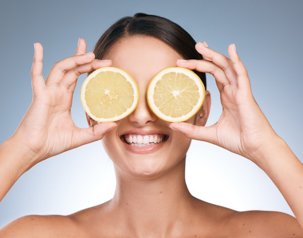 一名漂亮的年轻女子在蓝色背景下摆出橙色的姿势图片下载