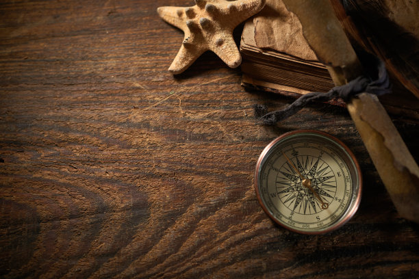 一个海洋的概念与瓶子，海星，贝壳，绳子，指南针和纸卷轴，海盗的静物图片下载