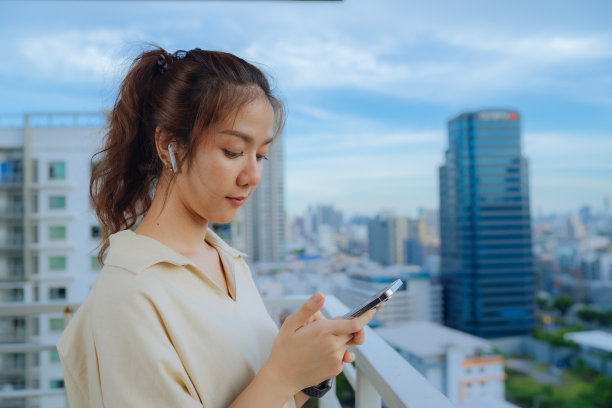 漂亮的亚洲女人在客厅用智能手机图片下载