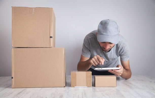 快递员使用平板电脑。产品、商业、零售图片下载