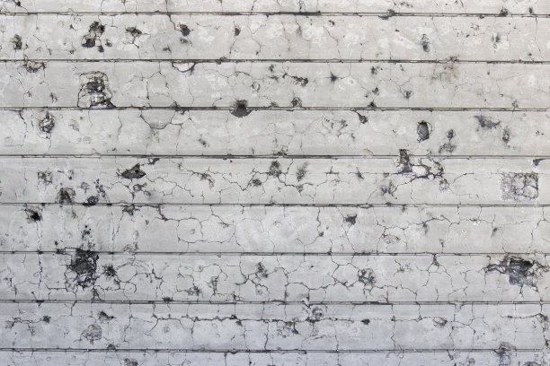 带有弹孔的墙壁背景。图片下载