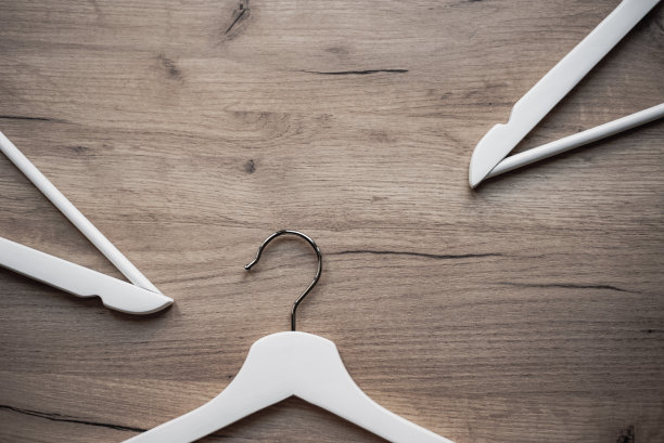 木制背景上带有金属钩子的木制衣架碎片。销售服装或个人用品的设备图片下载