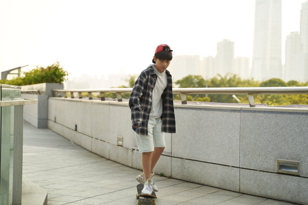 亚洲少年在户外玩滑板图片下载