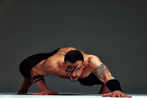 动物本能健身教练运动员展示了他令人难以置信的灵活性与动物流动在工作室对灰色背景图片下载