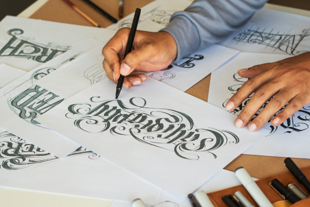 字体印刷书法艺术家设计师画草图写让拼写钢笔毛笔墨水纸桌子艺术品。工作场所的设计工作室。图片下载