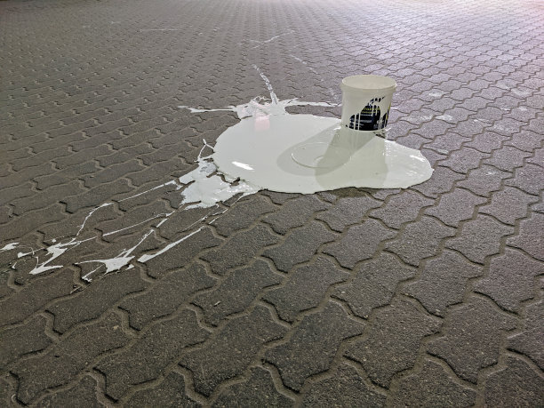 一桶白漆洒在铺路板上图片下载