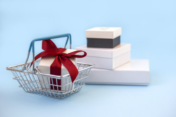 白色礼品盒红色蝴蝶结在超市篮白色礼品盒背景图片下载