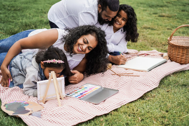 快乐的印度家庭与孩子在城市公园户外绘画-关注母亲的脸图片下载