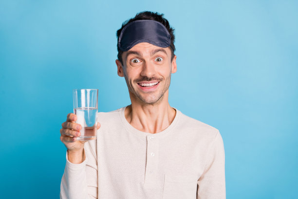 照片肖像兴奋的家伙拿着水杯在一只手孤立在生动的蓝色背景图片下载