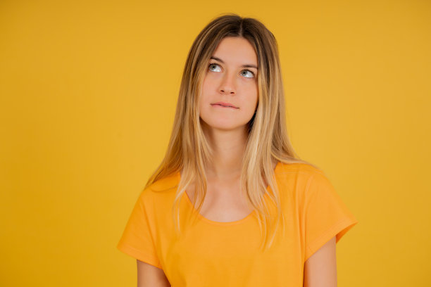 一个无聊的年轻女人站在一个孤立的背景上。图片下载