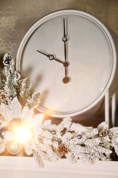 圣诞节白色时钟与节日装饰近距离在壁炉图片下载