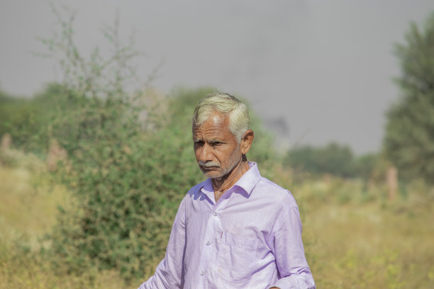 特写的老年农民男子行走在野生森林在印度穿着白衬衫和模糊的背景的自然图片下载