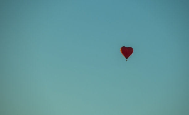 蓝色背景上的红心形状的热气球图片下载