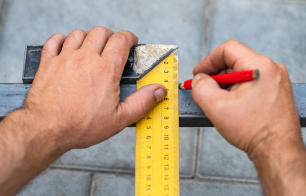 人们用尺子量金属以便切割图片下载