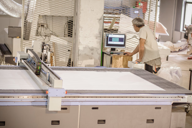 技术人员在数控数字切割机上工作，用于切割纺织品图片下载