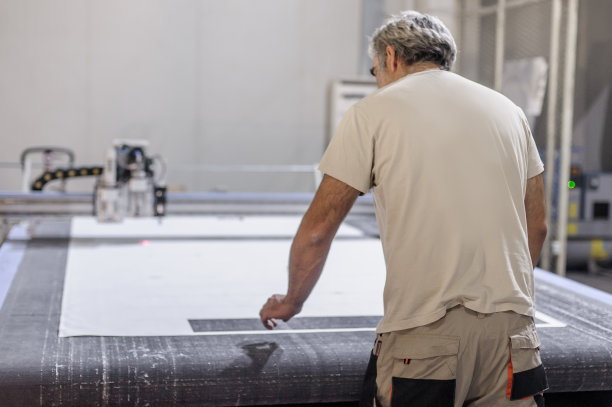 技术人员在数控数字切割机上工作，用于切割纺织品图片下载