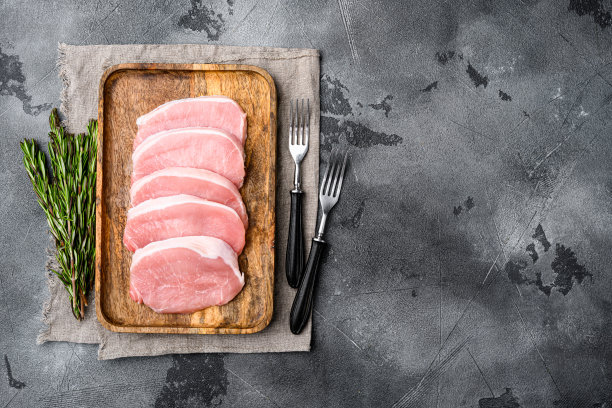 新鲜的猪肉，放在灰色的石桌背景上，顶视图平铺，带有文本复制空间图片下载