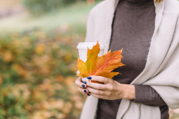 近距离照片的不认识的女人在棕色毛衣和米色围巾。图片下载