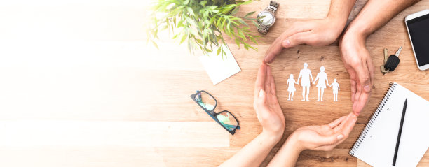 家庭护理的概念。手与纸剪影在桌上。图片下载