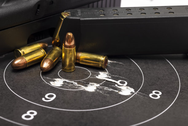 靶心纸靶上的子弹和半自动手枪背景图片下载