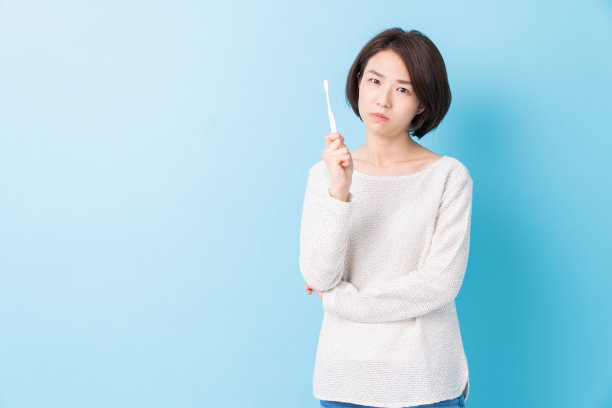 漂亮的亚洲女人用健康的牙齿拿着牙刷，口腔护理图片下载