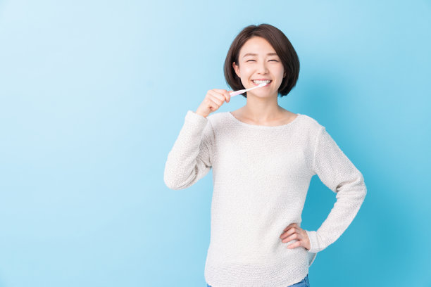 漂亮的亚洲女人用健康的牙齿拿着牙刷，口腔护理图片下载