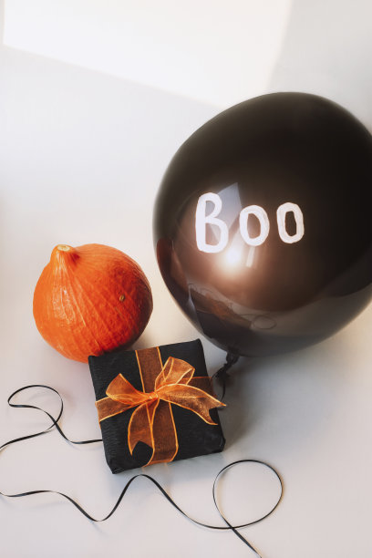 礼物在一个盒子里，橙色的北海道南瓜，白色背景上有单词Boo的黑色气球。万圣节的概念图片下载