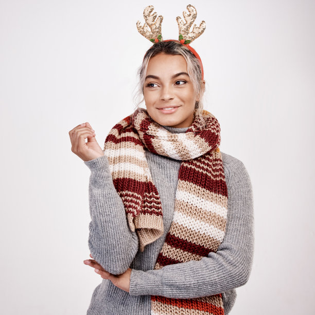 摄影棚拍摄了一个迷人的年轻女子，穿着圣诞主题服装，看起来若有所思图片下载