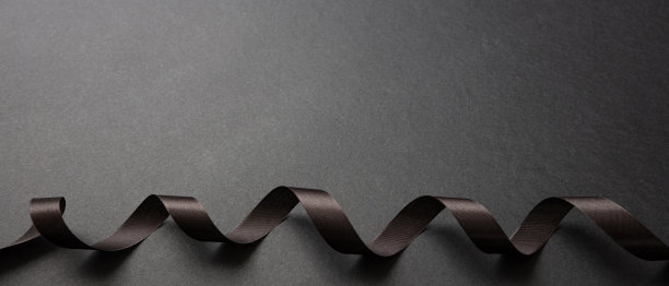 黑色丝带卷在黑暗的背景，复制空间。最小的卡片模板。黑色星期五促销概念图片下载