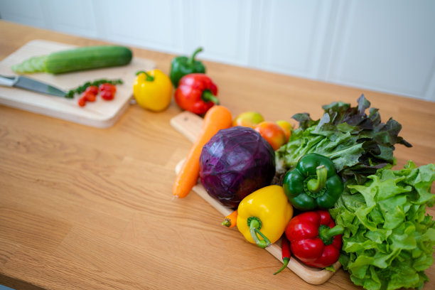 有蔬菜的厨房桌子和准备沙拉的切菜板。图片下载