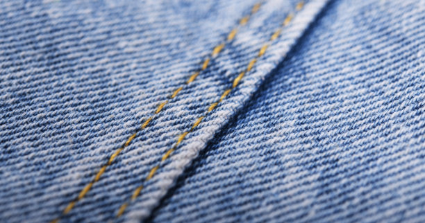 旧的蓝色牛仔裤背景和纹理接近。牛仔布缝。图片下载