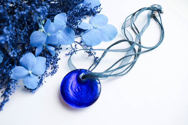 一束蓝色的花朵和珠宝。蓝色石吊坠图片下载