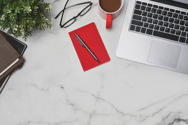 俯视图笔记本，笔记本电脑，咖啡杯和玻璃杯在大理石桌上。图片下载