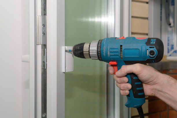 用螺丝刀把把手固定在塑料门上图片下载