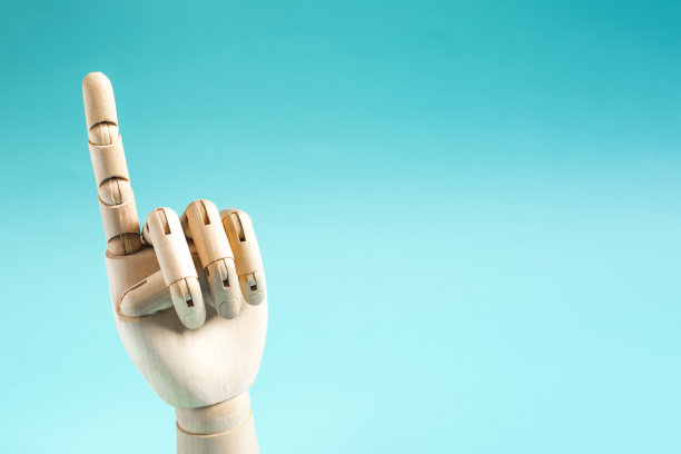 一只在蓝色背景上竖起手指的木手。概念性手势警告或注意图片下载