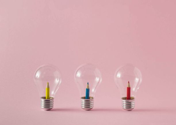 黄色、蓝色和红色的木制蜡笔在淡粉色的背景上。最小的概念。图片下载