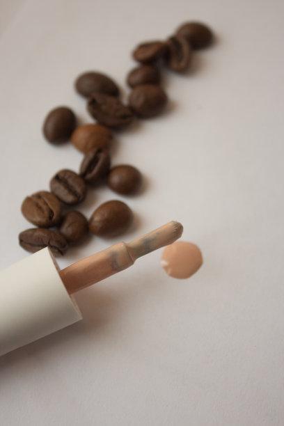 在白色背景的裸色指甲油和咖啡豆图片下载