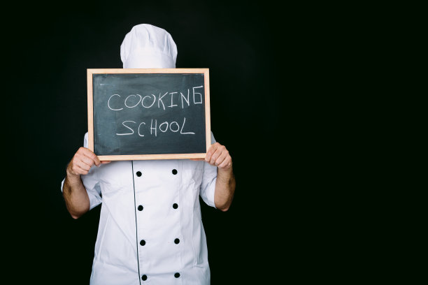 厨师用写有烹饪学校的黑板遮住脸图片下载