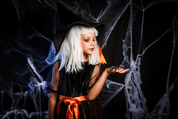 穿着女巫万圣节服装的小女孩玩得很开心。小女巫图片下载