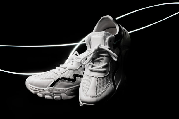 时尚白鞋配件脚。黑色背景上的移动灯光，生活方式中性的穿戴对象。图片下载