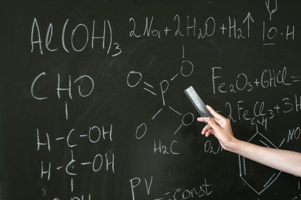 女老师在黑板旁边讲解化学式图片下载