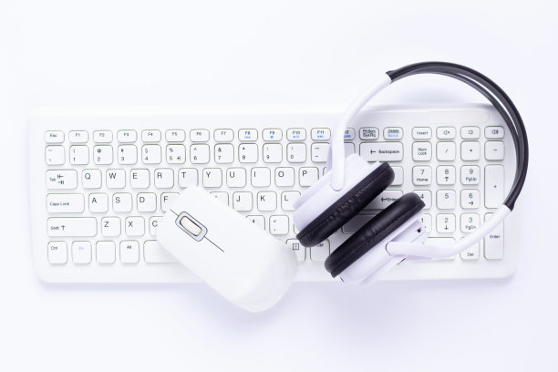 电脑键盘和鼠标在白色背景上。白色无线耳机图片下载