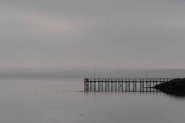防波堤，风平浪静，雾缭绕的海岸图片下载