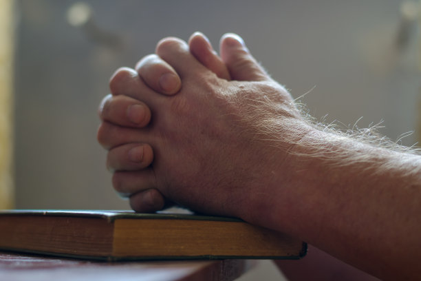 一张离焦的照片，两个人的手放在一本合着的书上。手掌佛图片下载