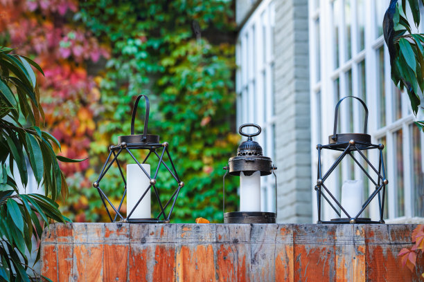 五彩的秋叶和三盏金属灯配上蜡烛，秋色斑斓的背景，复制空间图片下载