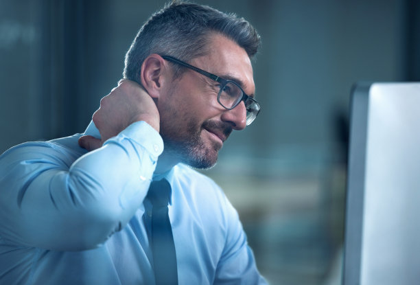 一张商人在办公桌前工作时脖子疼的照片图片下载